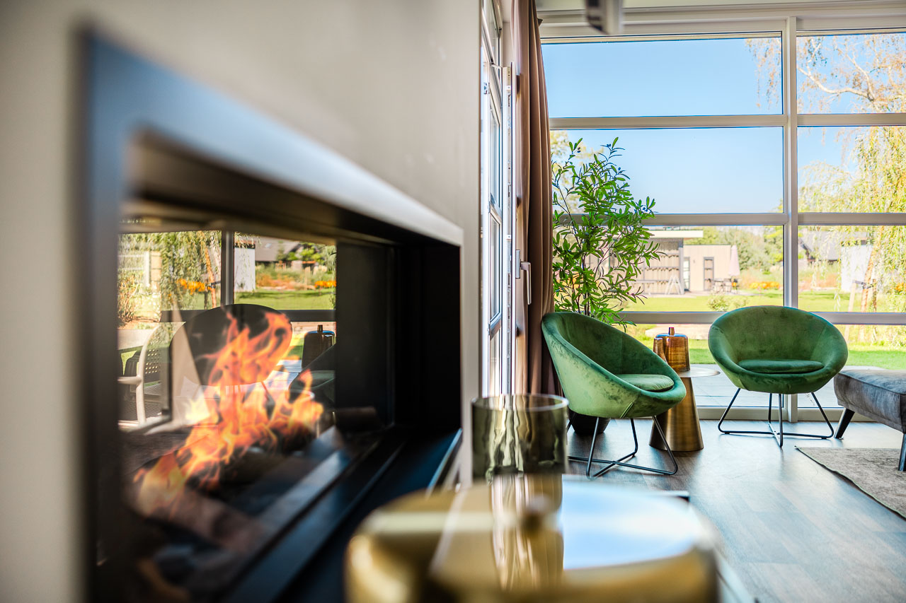 Woonkamer open haard met groene fauteuils